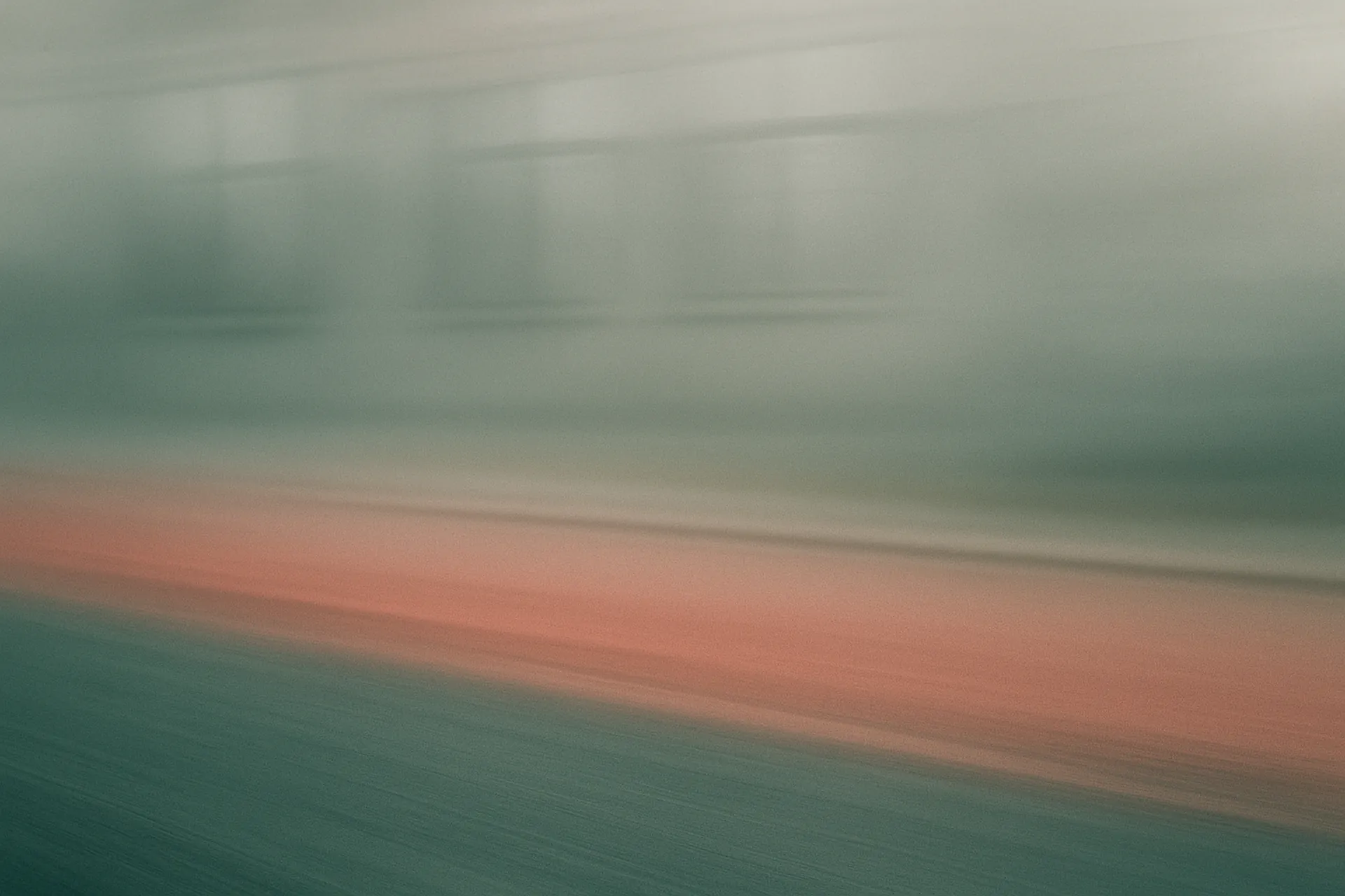 Blurred motion view of a misty road with green and red tones.