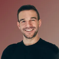 Moritz Doering with short dark hair and light beard wearing a black shirt against a gradient brown background.